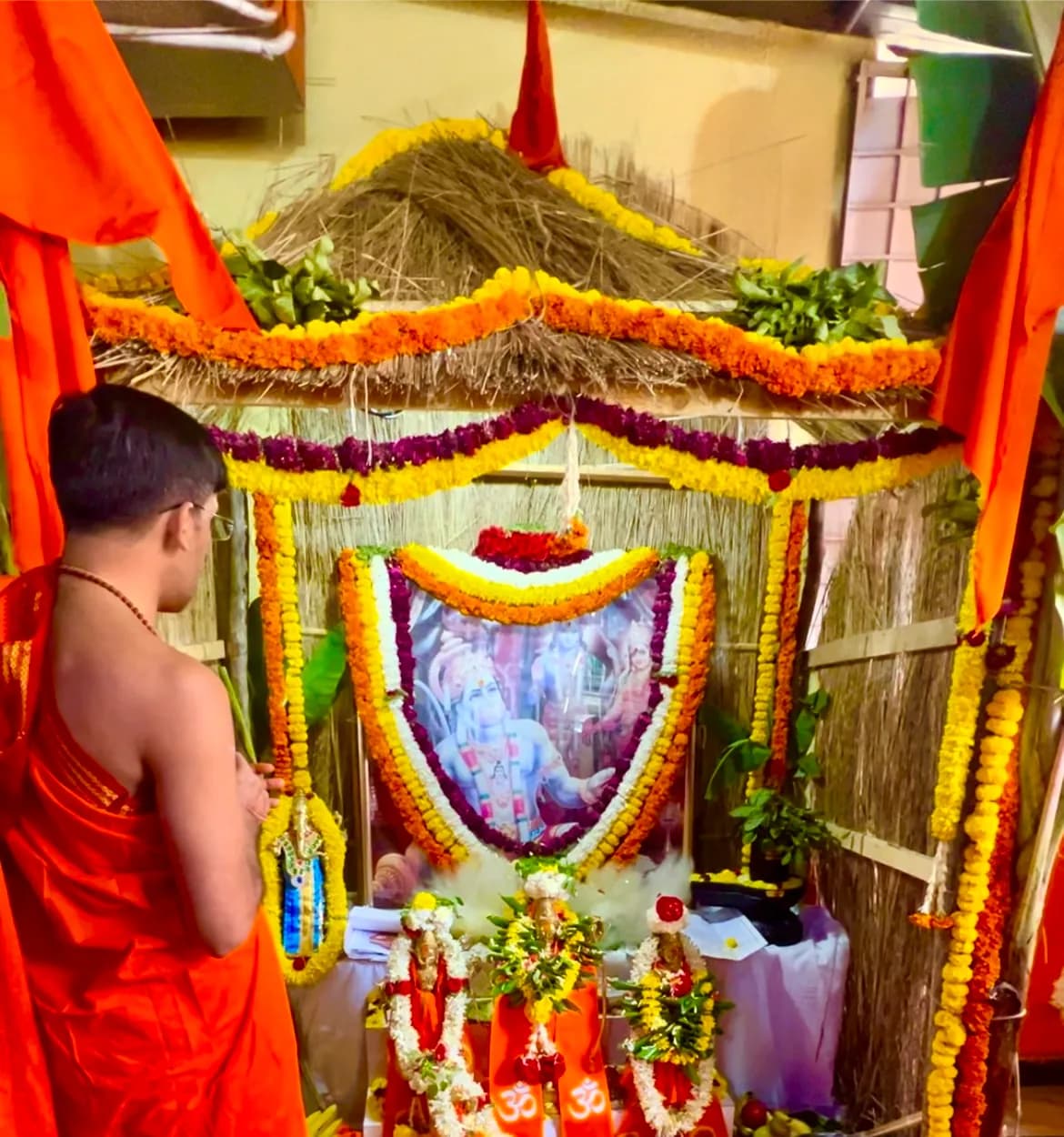 Pandit before a decorated shrine
